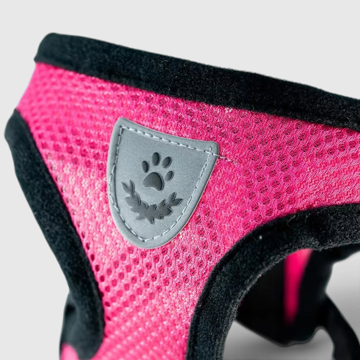 Maille rose et écusson à patte du harnais chat en gros plan